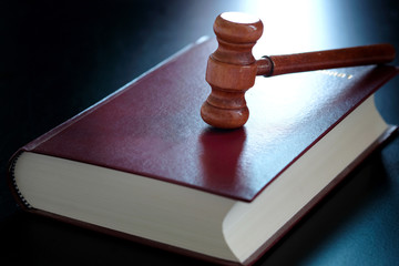 Judge's hammer Put on law books. On a black background . law concepts and protection