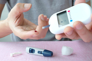 hand of people check diabetes and high blood glucose monitor with digital pressure gauge....