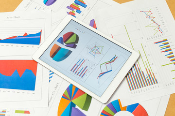 Financial charts on the table with tablet