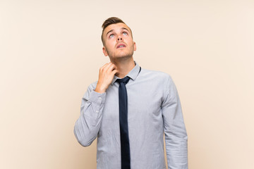 Young blonde businessman over isolated background thinking an idea