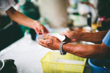 Volunteers donate free charity food to the homeless, the concept of human hunger.