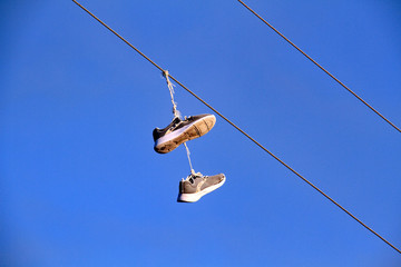 Shoes hang from power line cables 