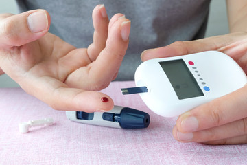 hand of people check diabetes and high blood glucose monitor with digital pressure gauge. Healthcare and Medical concept