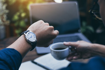 looking at luxury watch on hand check the time at workplace.concept for managing time organization...