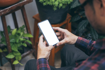 Mockup image blank white screen cell phone.hand holding texting using mobile background empty space for advertise text.people contact marketing business,technology 