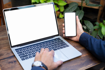 mockup image blank screen computer,cell phone with white background for advertising text,hand man using laptop texting mobile contact business search information on desk in cafe.marketing,design