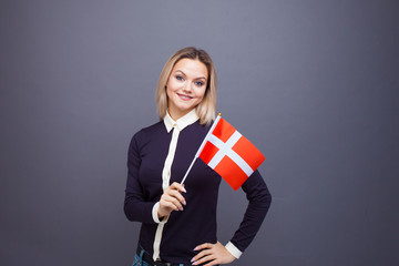 Immigration and the study of foreign languages, concept. A young smiling woman with a Denmark flag...