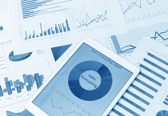 Financial charts on the table with tablet