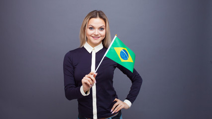 Immigration and the study of foreign languages, concept. A young smiling woman with a Brazil flag...
