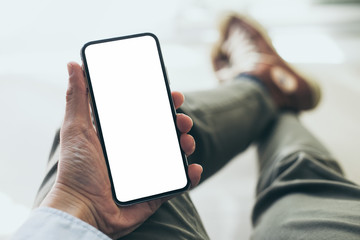 Mockup image blank white screen cell phone.man hand holding texting using mobile at home office.background empty space for advertise text.people contact marketing business,technology