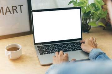 mockup image blank screen computer with blank white background for advertising text,hand man using laptop contact business search information on desk at home office.marketing and creative design