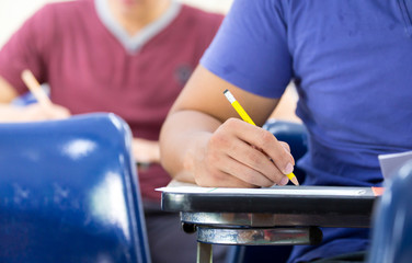 high school,university student study.hands holding pencil writing paper answer sheet.sitting lecture chair taking final exam attending in examination classroom.concept scholarship for education abroad
