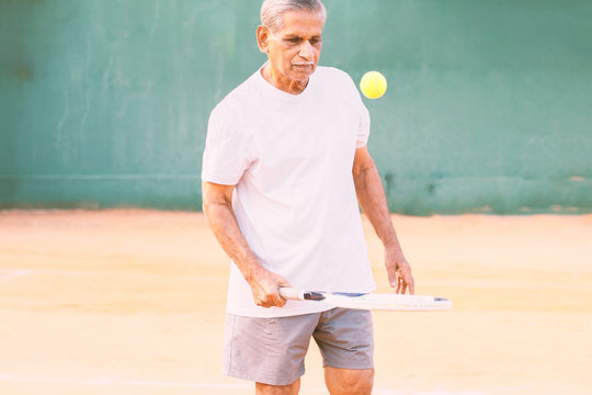 Elderly Man Playing Tennis - Concept Of Healthy And Fit Old People - Senior Player Practicing Tennis.