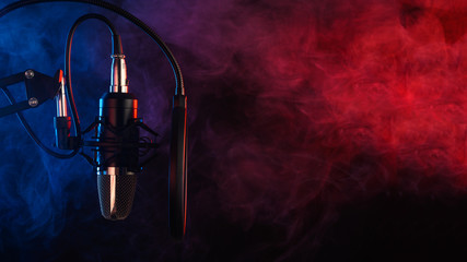 Close up studio condenser microphone on stand and anti-vibration mount. Live recording with colored...