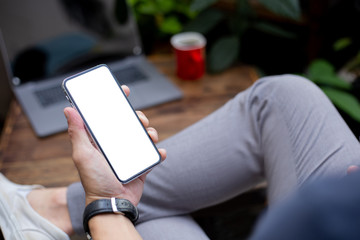 Mockup image blank white screen cell phone.man hand holding texting using mobile on desk at home office.background empty space for advertise text.people contact marketing business,technology