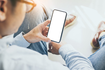 Mockup image blank white screen cell phone.man hand holding texting using mobile sitting at home.background empty space for advertise text.people contact marketing business,technology