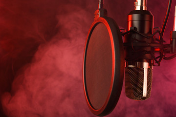 close-up. Studio condenser microphone Radio, vocals, podcasts red smoke. Copy space.