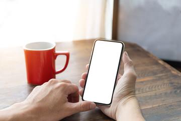 Mockup image blank white screen cell phone.man hand holding texting using mobile on desk at home office.background empty space for advertise text.people contact marketing business,technology