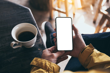 Mockup image blank white screen cell phone.man hand holding texting using mobile on desk at coffee shop.background empty space for advertise text.people contact marketing business,technology