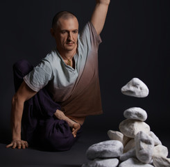 Man sitting on the floor in yoga pose studio shot