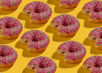 Fototapeta na wymiar Pop art collage of bitten glazed donuts on a yellow background. Food background