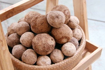 Light brown of EM balls in brown craft basket on wood table, Thailand.