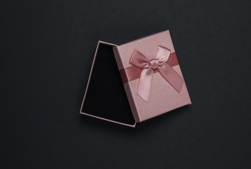Open Gift box with bow on black background. Composition for christmas, birthday or wedding. Top view