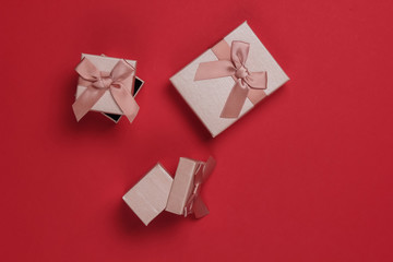Gift boxes with bows on red studio background. Composition for christmas, birthday or wedding.