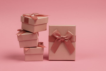 Stack of Gift boxes with bows on pink pastel background. Composition for christmas, birthday or wedding.
