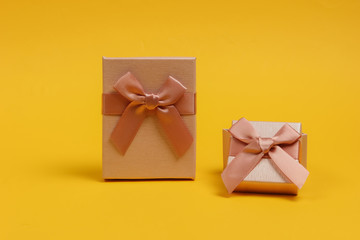 Gift boxes with bows on yellow studio background. Composition for christmas, birthday or wedding.