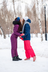 Fototapeta na wymiar Portrait of two young beautiful women in ski suit posing in winter in the park