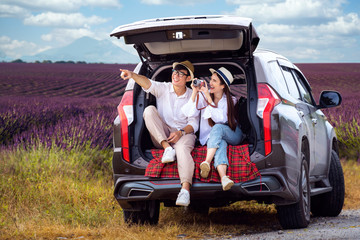 Asian couple travel by a car in lavender field