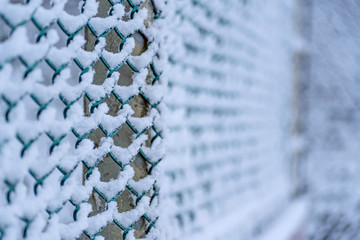 Chainlink fence covered by snow-narrow field of focus