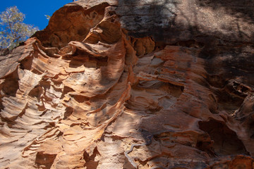 Crumbling sandstone walls with a pattern in the form of stone waves. Sandstone Caves, Pilliga National Park, NSW, Australia.