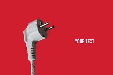 Electric plug closeup on red background. Copy space