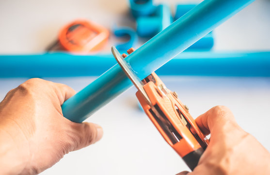 A plumber cut PVC pipe with PVC pipe cutting pliers tool .selective focus .Plumbing Repair and maintenance concept