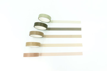 Close up top view of paper masking tape in set of green arranging in a row and taping on board....