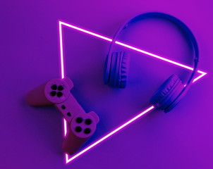 Gаmer concept. Gamepad with headphones. 80's synth wave and retrowave glowing triangle futuristic aesthetics. Old fashioned abstraction concept