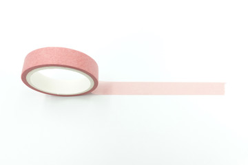 Close up side view of paper masking tape in green and pink sets stacking up in a roll isolated on white background with copy space.