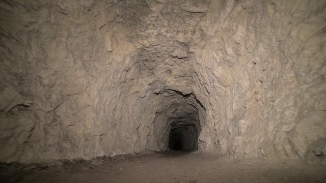Speleology artificial cave dark tunnel excavation underground. Old adit for the extraction of metal and rocks