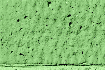 Brick wall texture close-up lit by the sun. Abstract background green color toned
