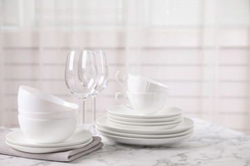 Set of clean tableware on white marble table