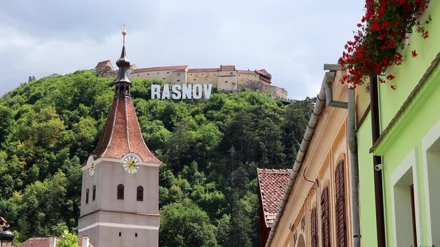 View of the the famous Rasnov city sign and Clock tower of the Saint Matthias evangelical church