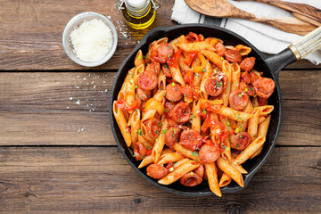 Penne Pasta with grilled sausage and tomato sauce served with parmesan cheese.