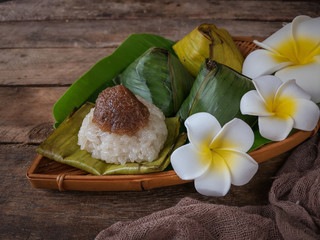 A Malay traditional dessert called Pulut Manis on bamboo dustpan over wooden background.