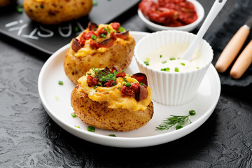 Hot baked potato topped with bacon, green onions and sun dried tomatoes.