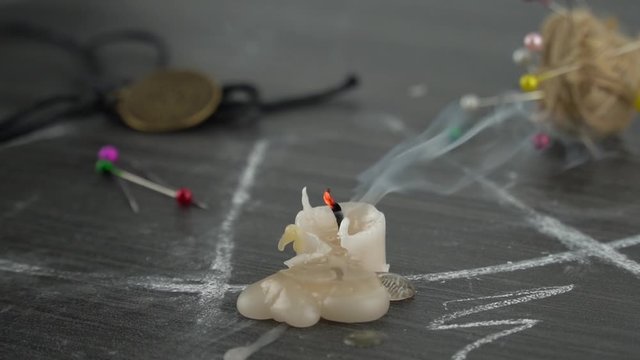 a candle melts on a table with an occult circle. conducting a seance, a mystical ritual. 