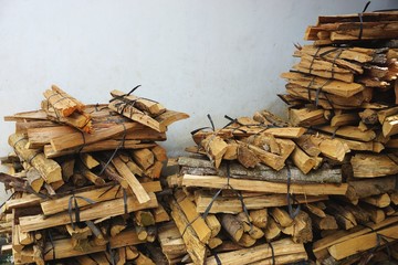 Bundles of kindling firewood stacked against a wall