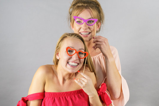 Women with party decoration mask stick glasses