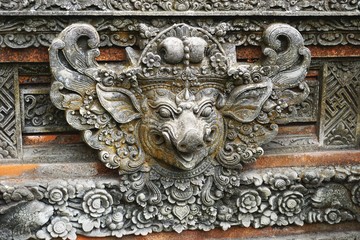 Ancient carved stone boar head on a Hindu temple in Bali Indonesia
